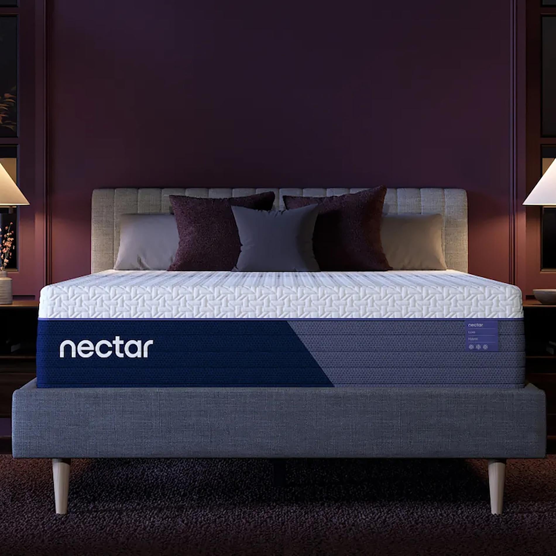 Nectar mattress on a bed with decorative pillows against a dark purple wall.