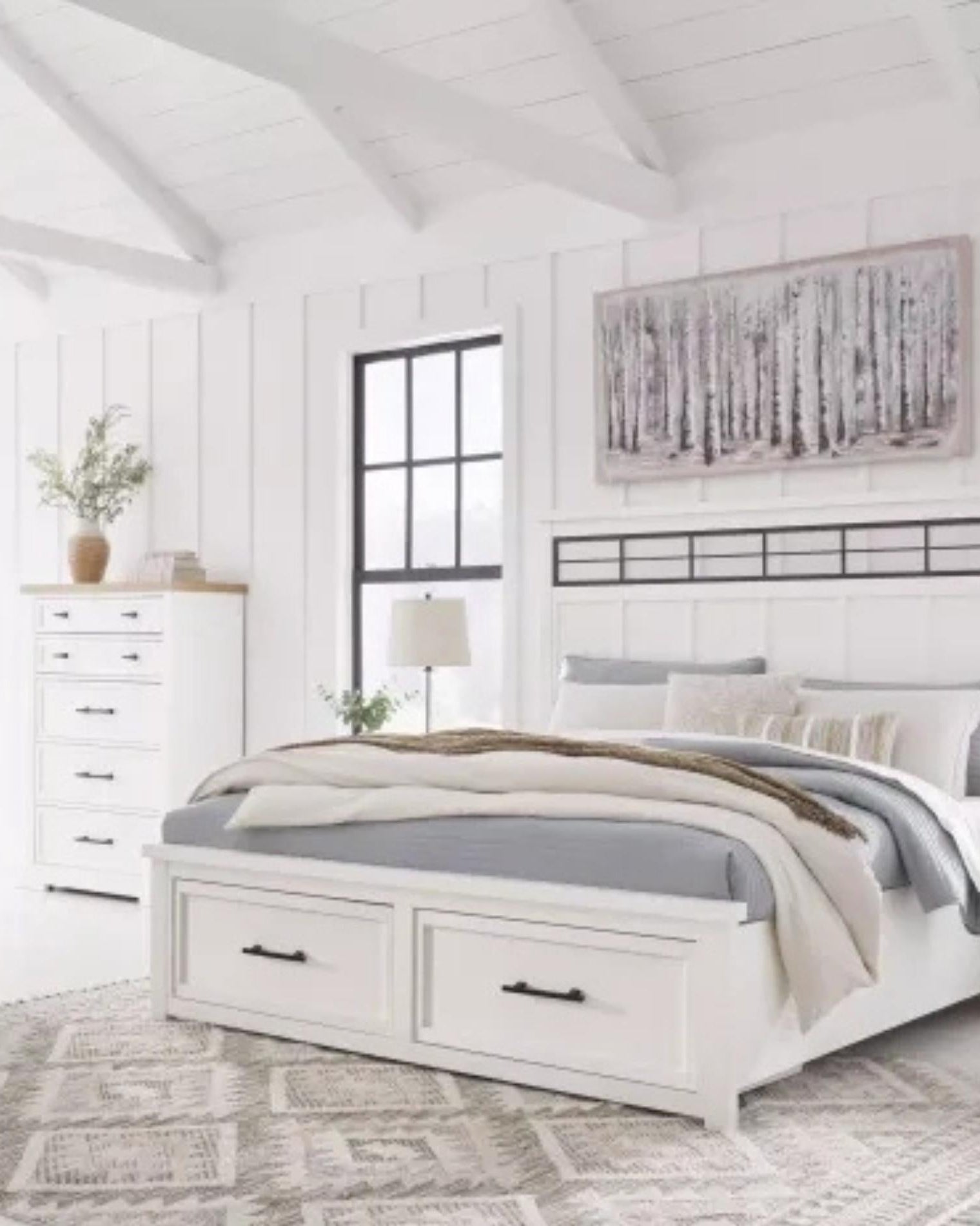 Neatly arranged bedroom with a white bed, dresser, and decorative elements.