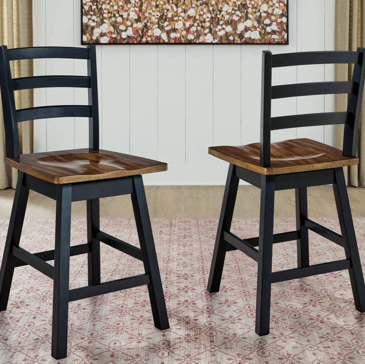 Two counter-height stools with black ladder-back frames and medium brown wooden seats, shown in a dining room setting with a patterned rug and wall art.