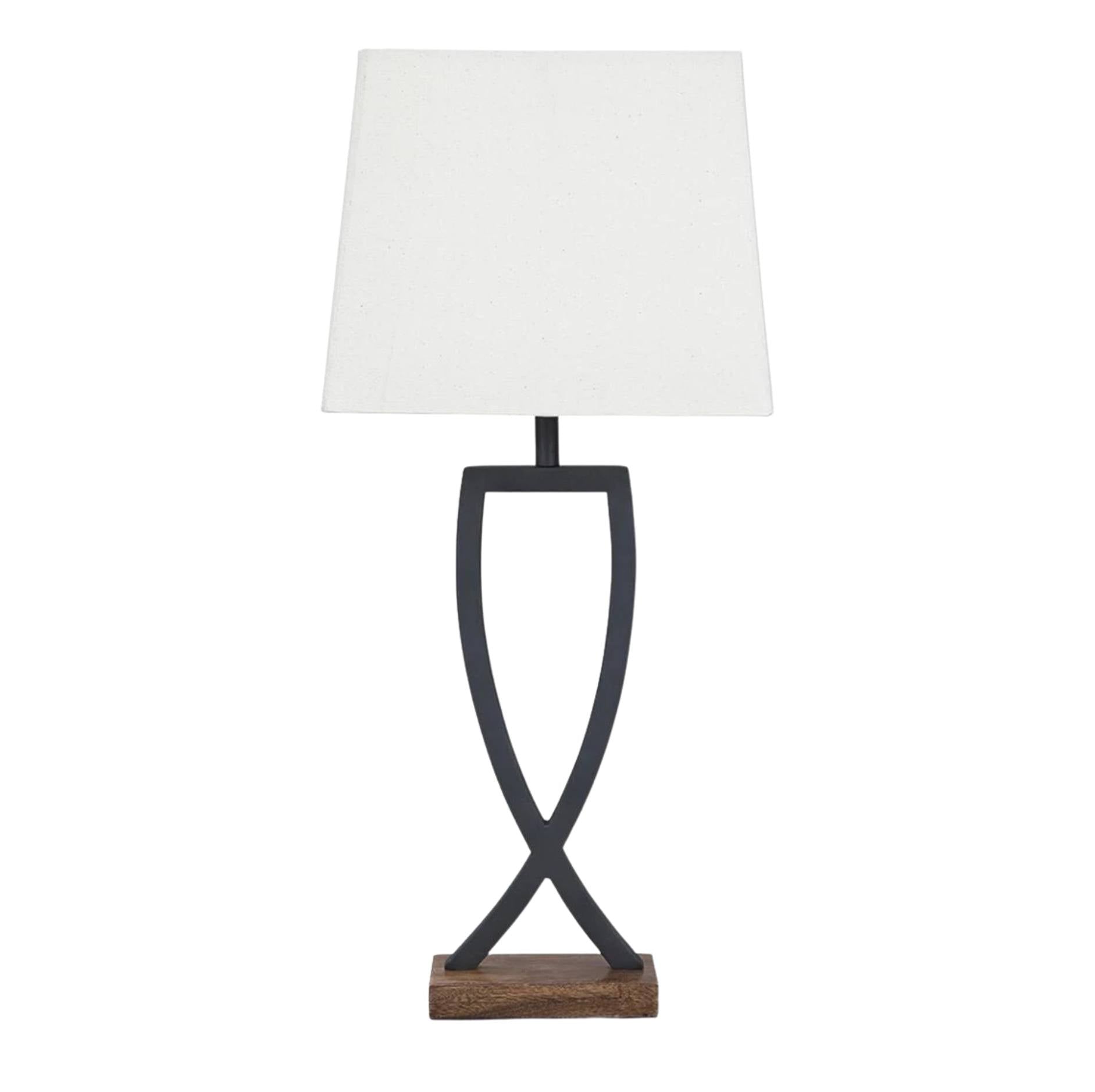 A table lamp with a white rectangular fabric shade, a dark metal sculptural base, and a small wooden base plate, shown on a plain white background.
