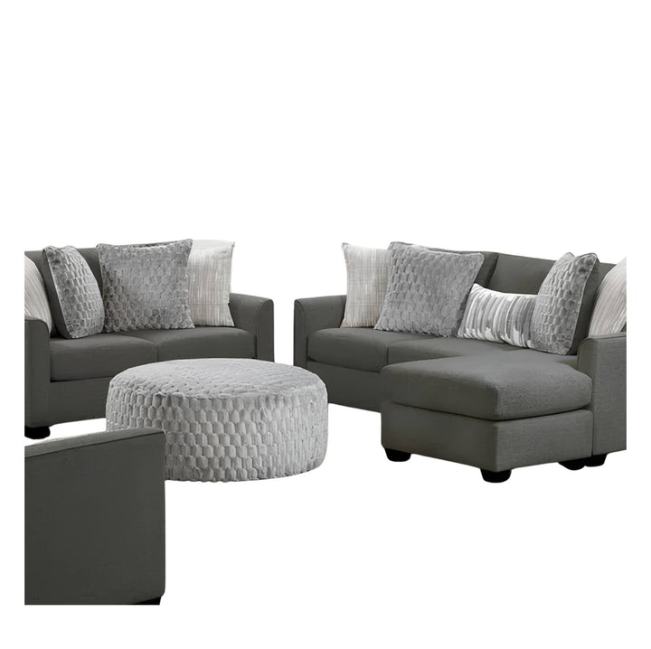 A gray sectional sofa set with a chaise, matching armchair, round ottoman, and multiple gray and white textured throw pillows on a plain white background.