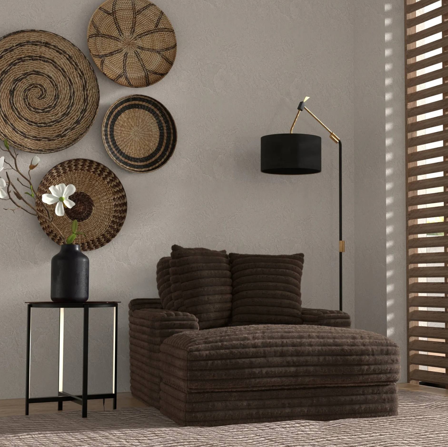 A dark brown textured chaise lounge chair in a styled room setting with a black side table, black floor lamp, and decorative woven wall baskets.