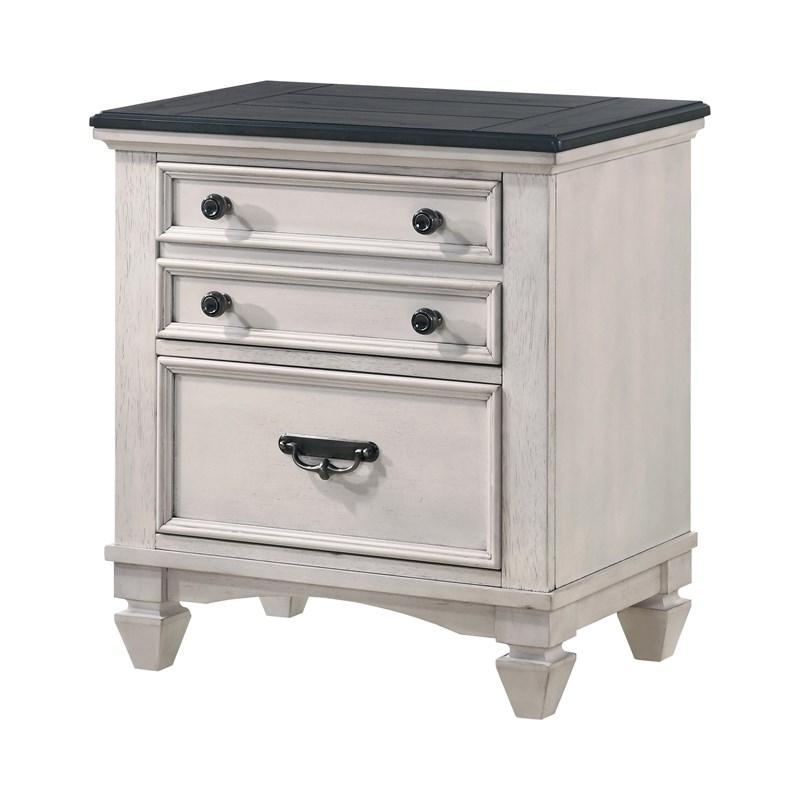 White nightstand with three drawers and a black top on a white background