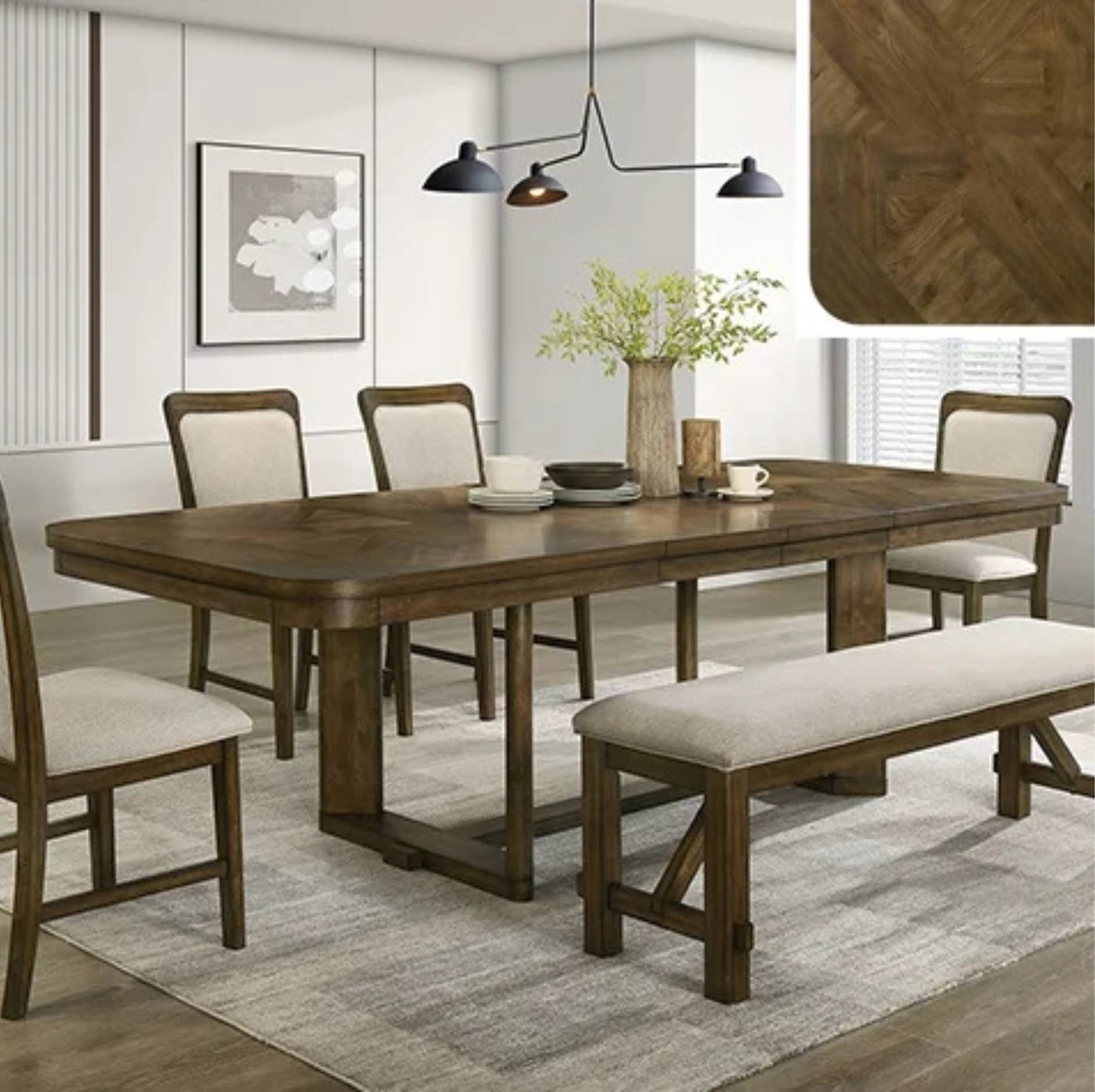 A rectangular wooden dining table set in a bright dining room, surrounded by four upholstered chairs and a matching bench. The table has a medium brown wood finish, and the chairs and bench have light beige cushions.
