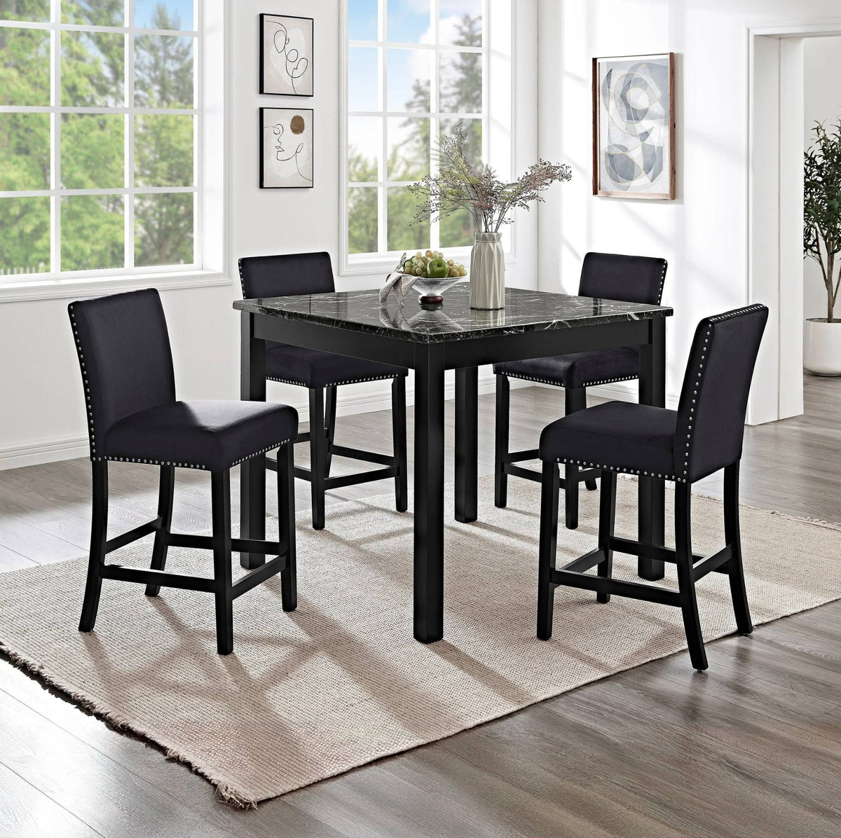 A 5-piece counter height dining set featuring a rectangular black marble-top table and four matching black bar stools with nailhead trim, shown in a bright, modern dining room.