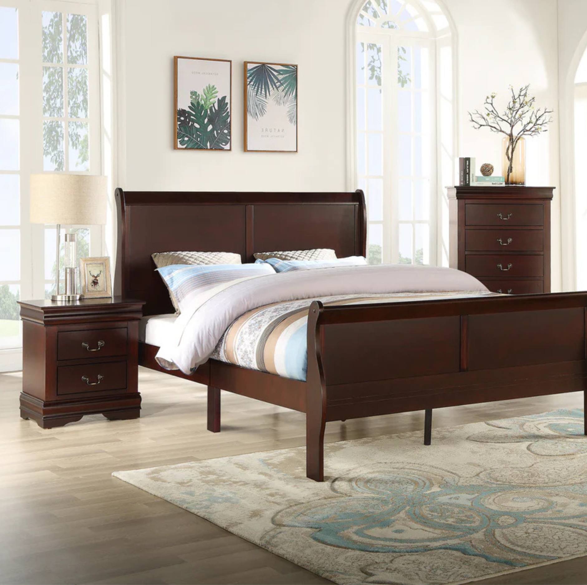 A dark brown wooden sleigh bed frame shown in a bright, modern bedroom setting with a matching nightstand, dresser, and patterned rug.