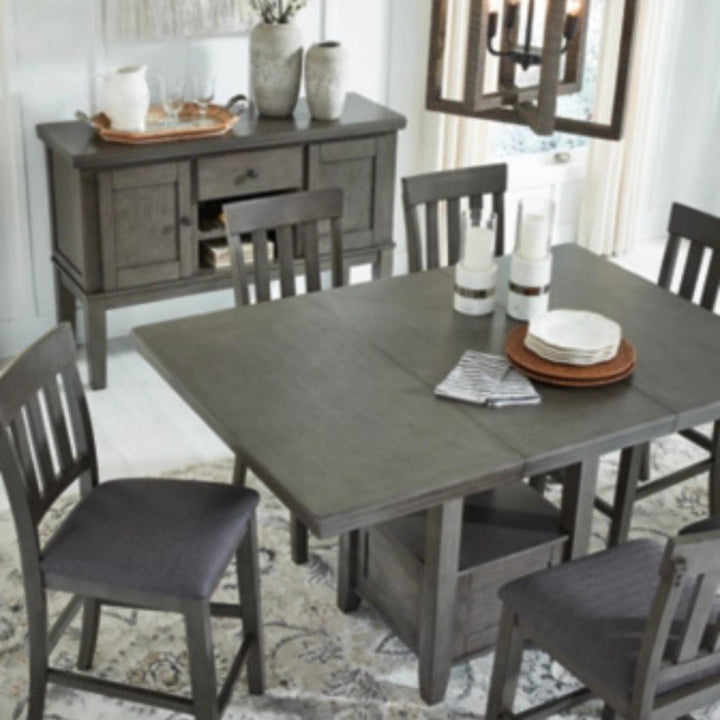 Dining room with gray table and chairs, sideboard, and decorative items.