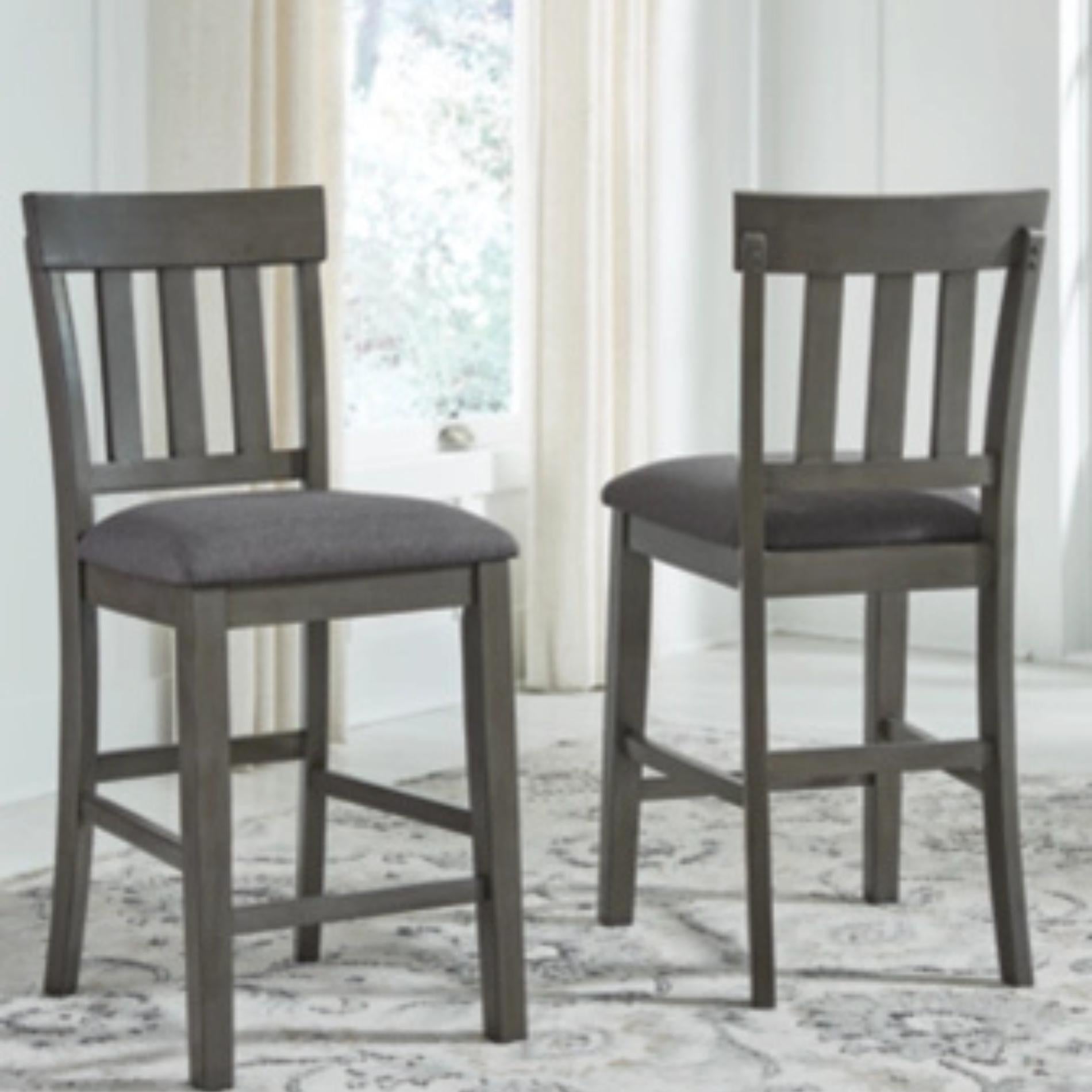 Two gray bar stools with cushioned seats on a patterned rug.
