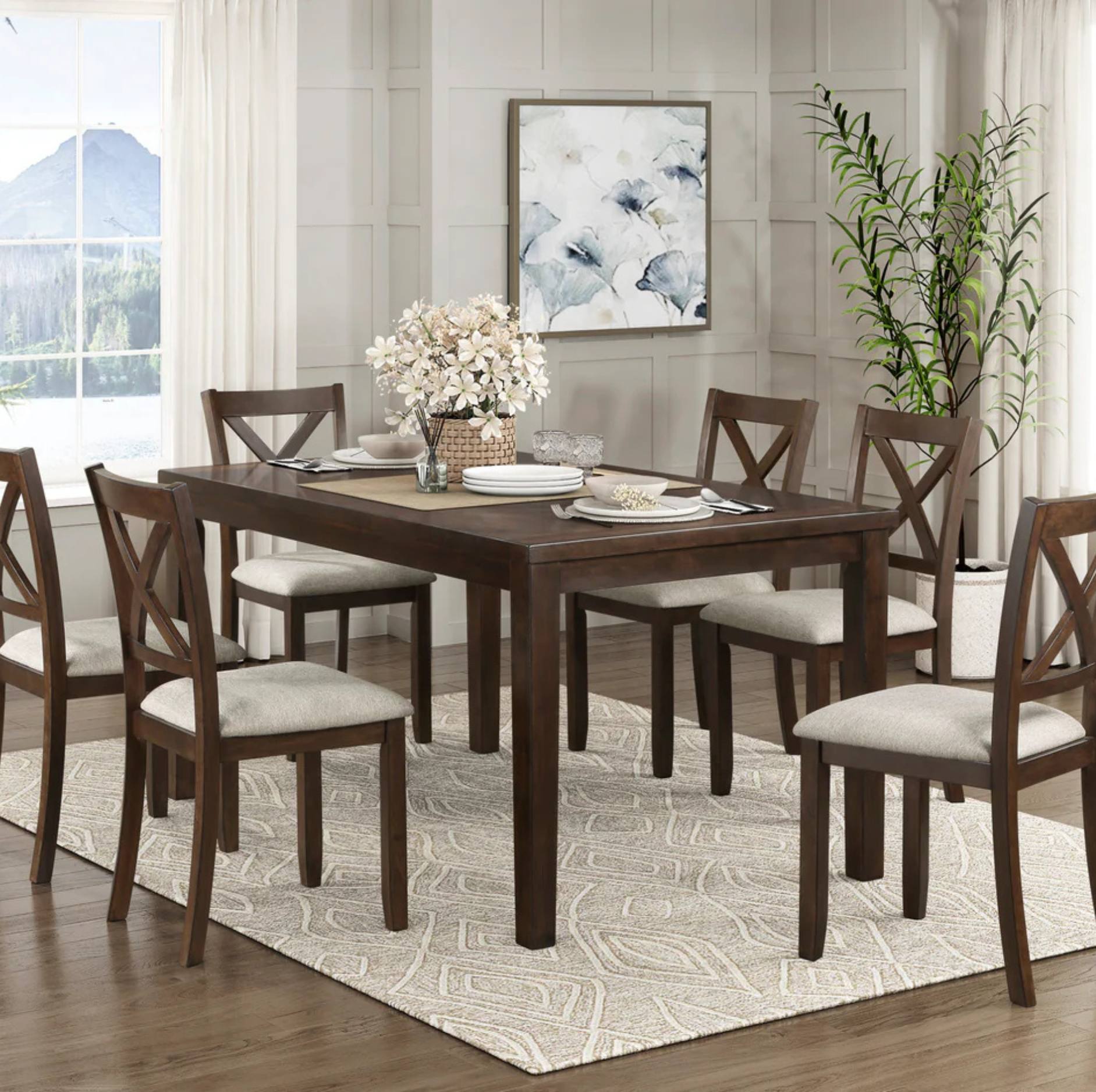 A 7-piece dark brown wooden dining table set with eight matching chairs featuring light beige upholstered seats, styled on a patterned cream rug in a bright dining room.