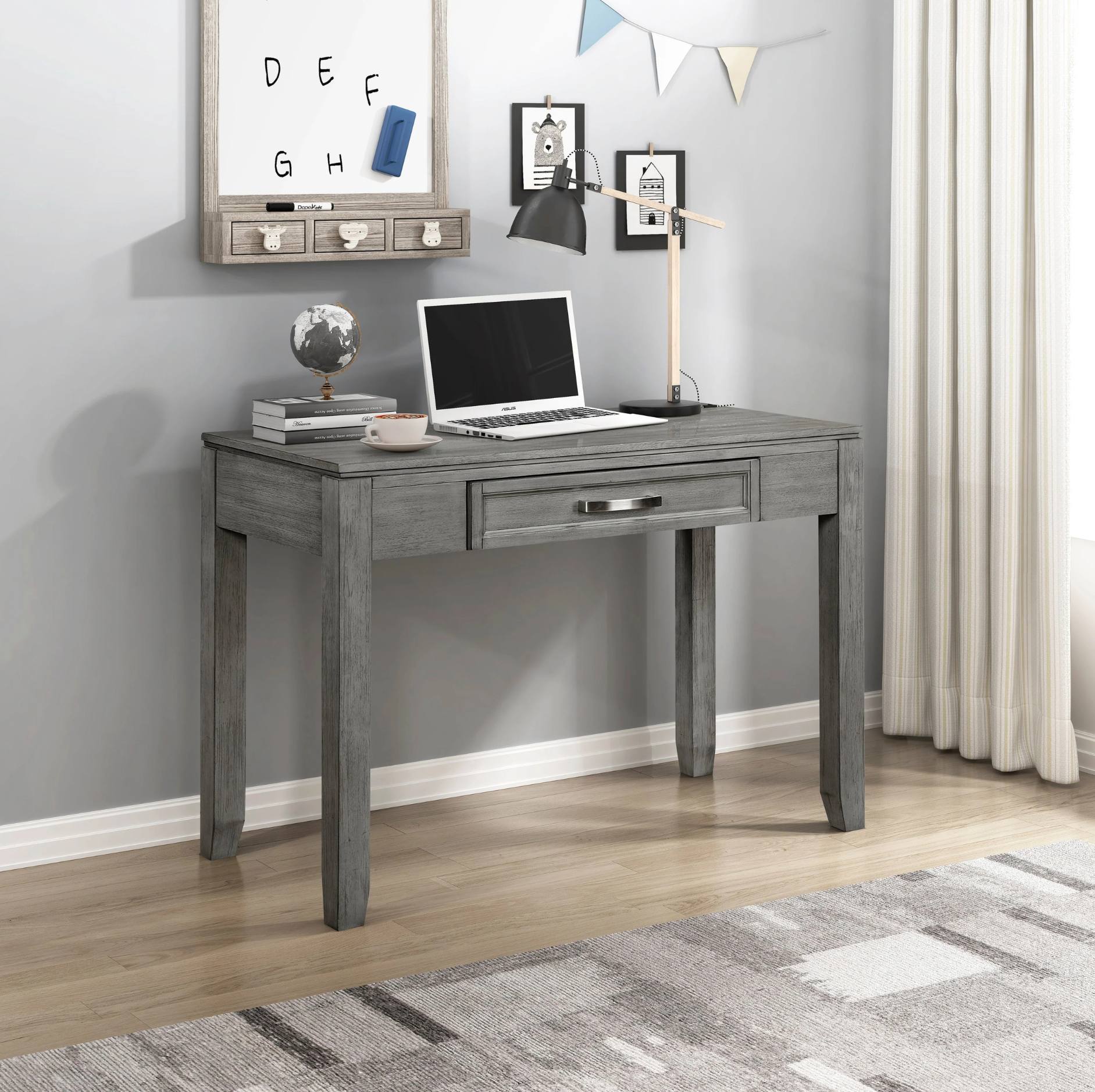 Gray wooden desk with a laptop, lamp, and decor items in a home office setting.