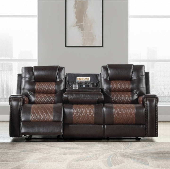 A three-seat reclining leather sofa in dark brown with medium brown diamond-quilted inserts on the seat and back cushions, shown in a staged living room setting with a patterned rug, gray wall, and framed art.