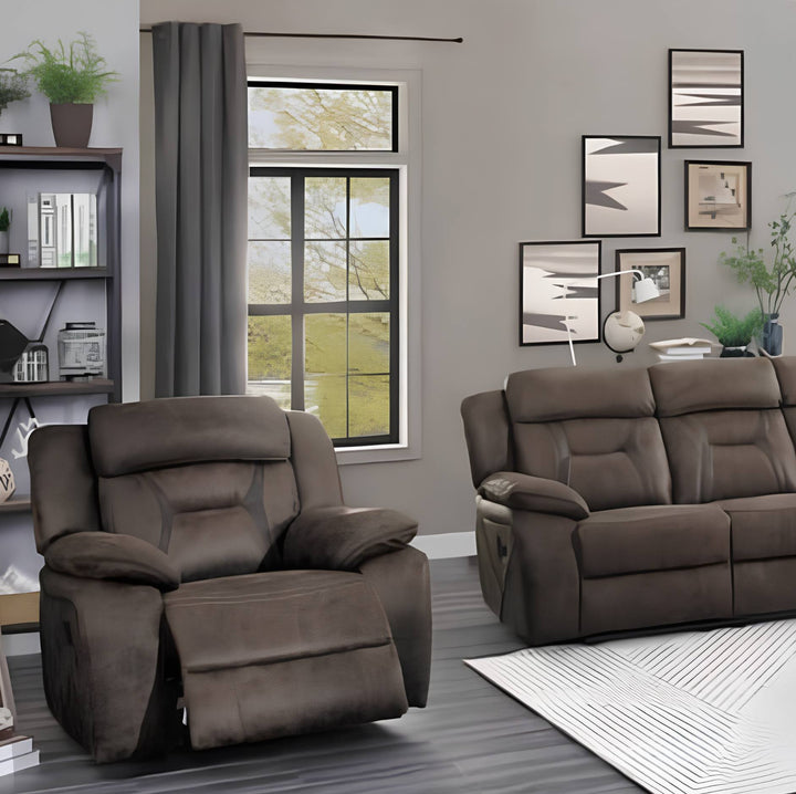 A brown recliner chair and matching brown loveseat sofa shown in a staged living room with gray walls, framed wall art, a window, curtains, shelving, and a rug.