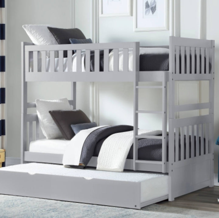 A light gray wooden bunk bed with a matching pull-out trundle bed, styled with white and dark gray bedding in a bright bedroom setting.