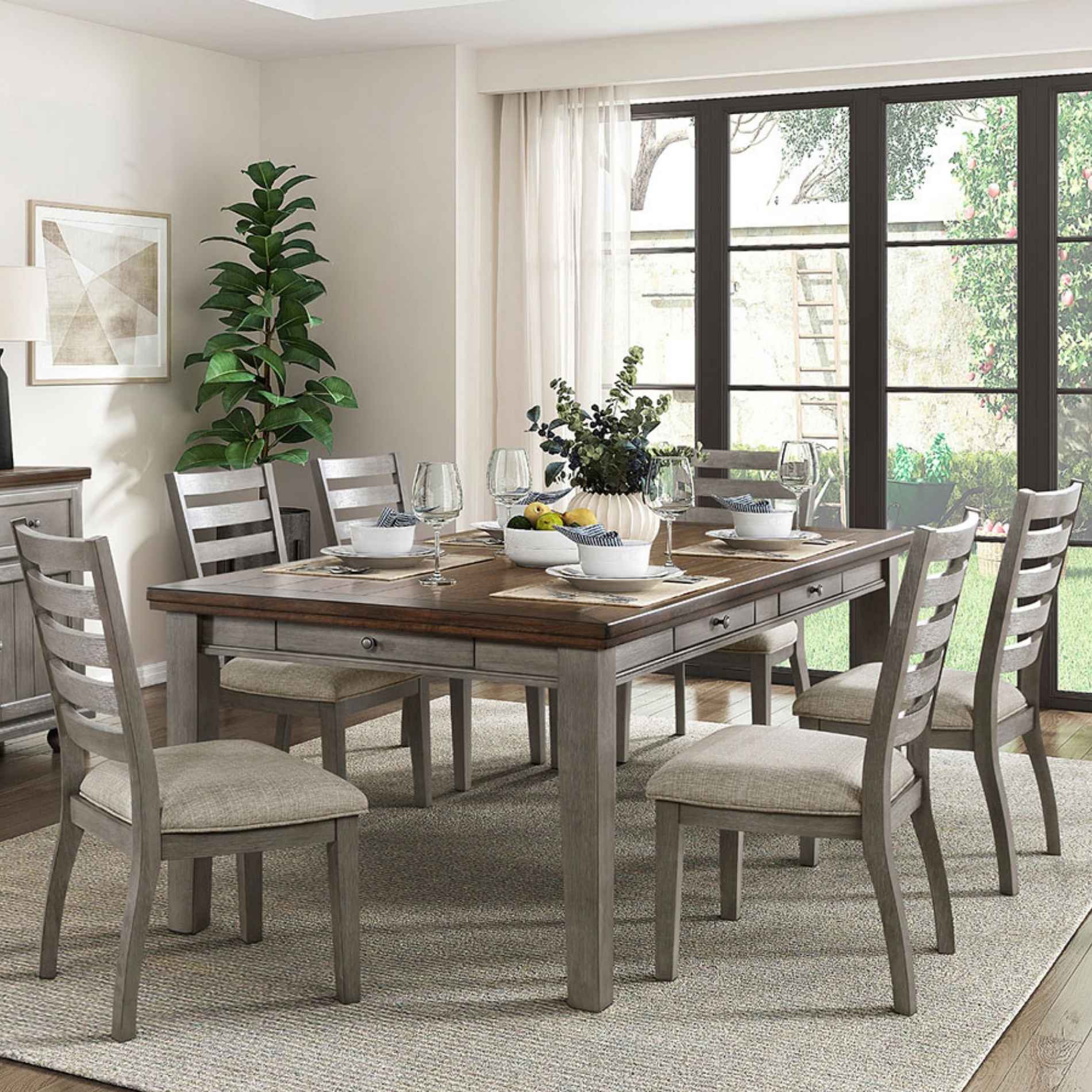 Dining room with a wooden table and gray chairs, decorated with plants and glasses.