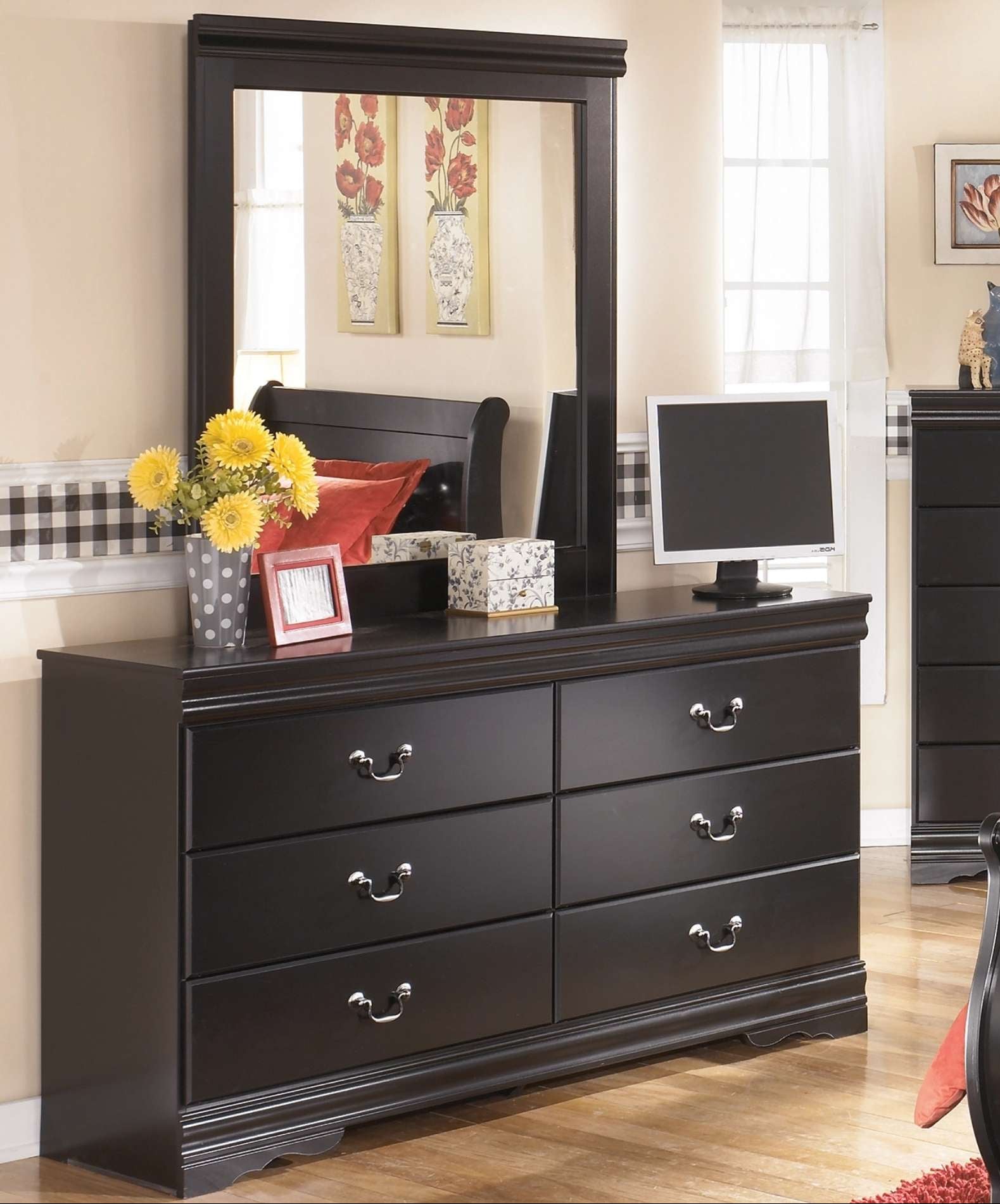 Black dresser with mirror in a room setting