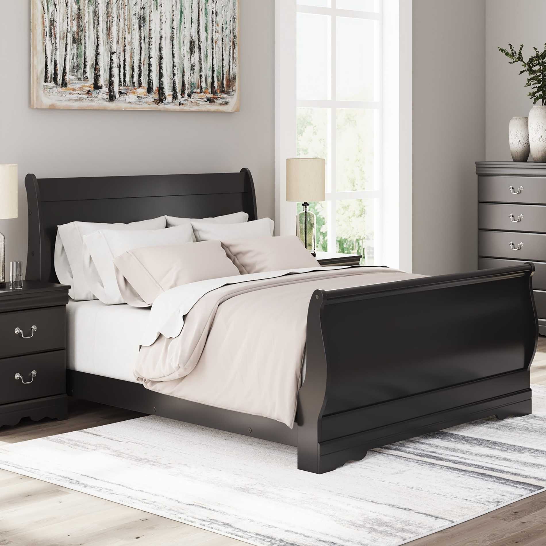 Black sleigh bed in a bedroom with white bedding and nightstands.