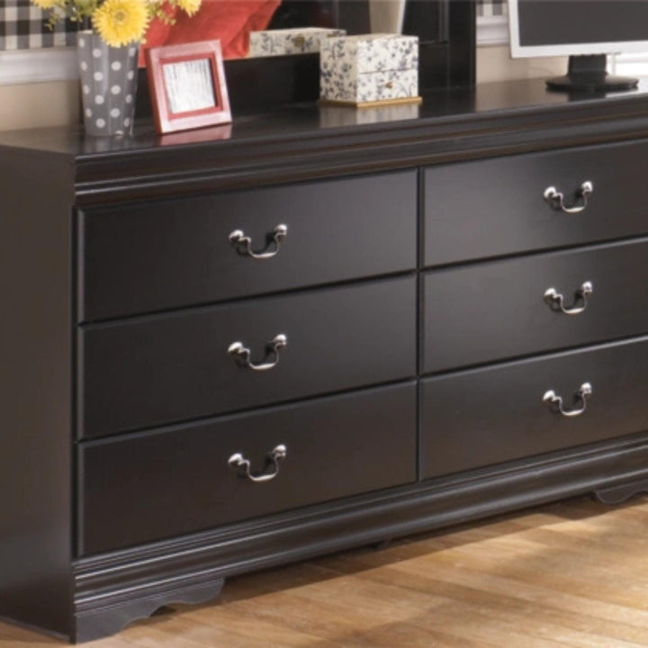 Black dresser with multiple drawers on a wooden floor