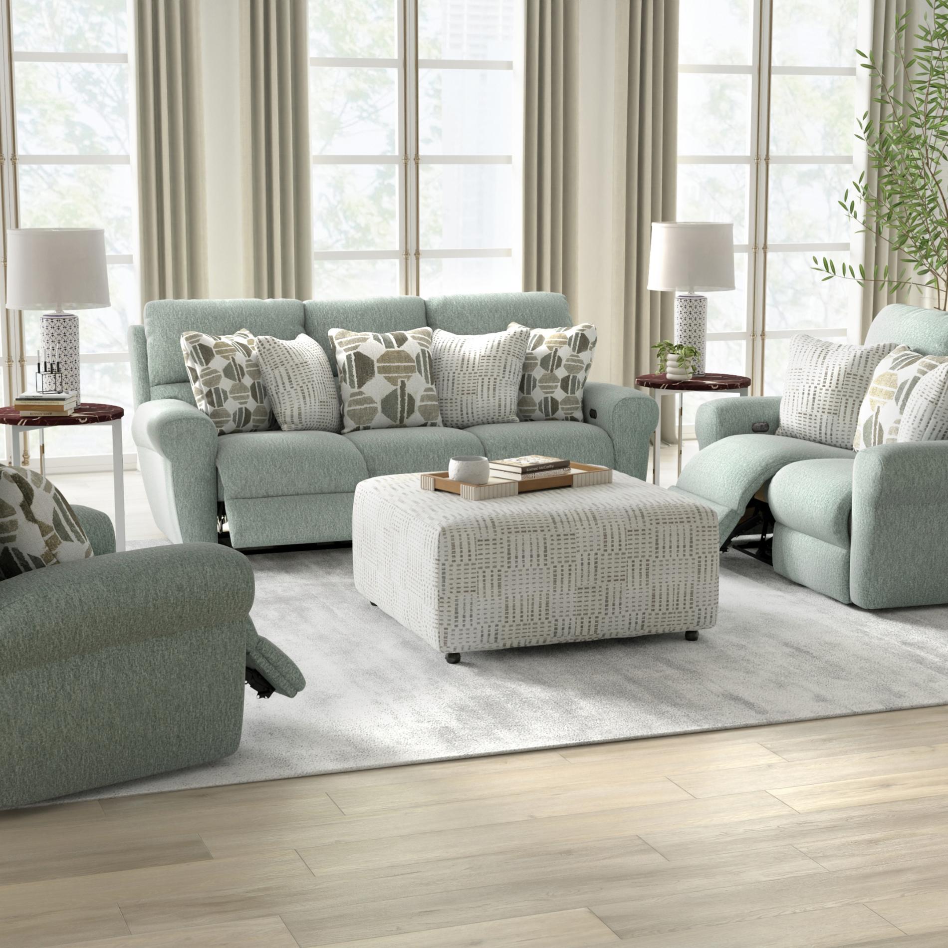 Living room with light gray sofa, armchair, and ottoman with decorative pillows.