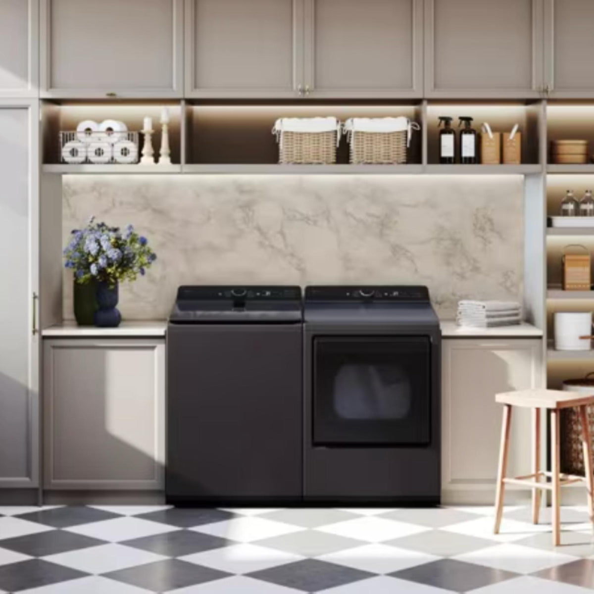Black washer and dryer set against a neutral-colored wall with shelves and decor.